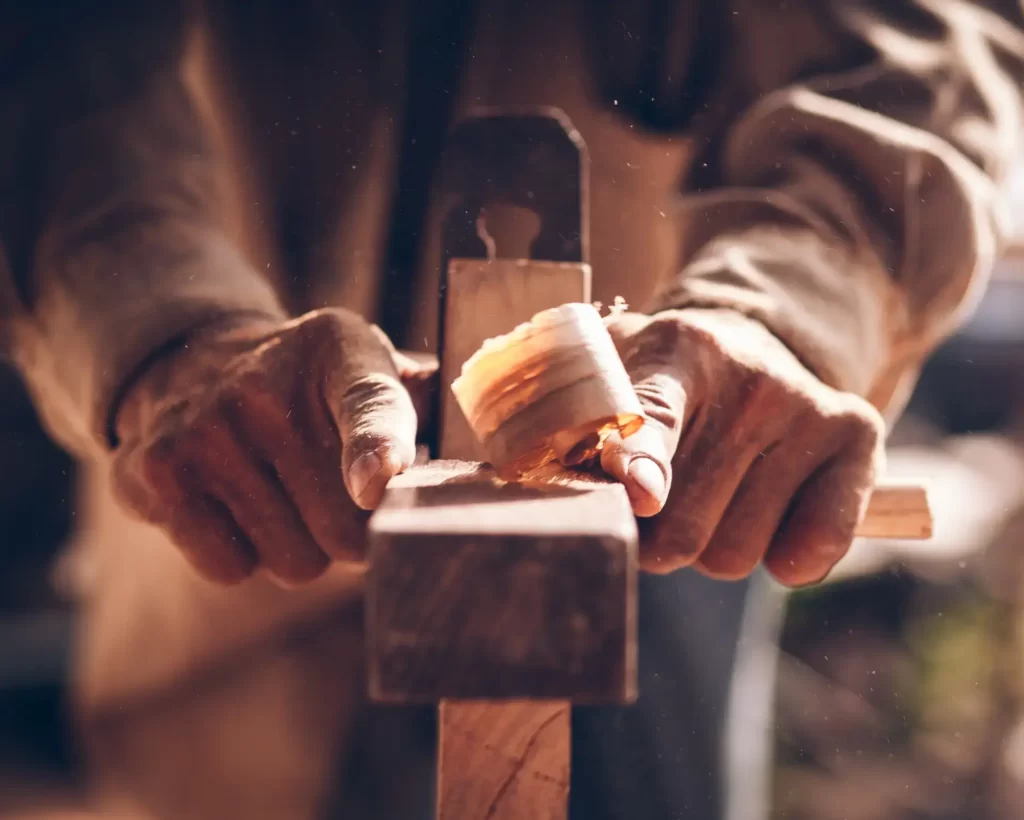 Mężczyzna ciosający drewno