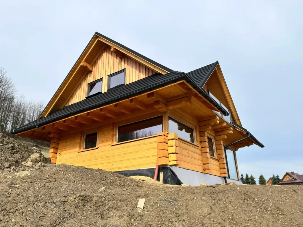 dom z bali na wzgórzu, w trakcie budowy, duże okna z widokiem na okolicę
