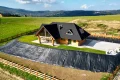 dom z bala na Złotym Groniu, widok na wyciąg narciarski za domem, skarpa obłożona folią, aranżacja ogrodu, drewniane ogrodzenie